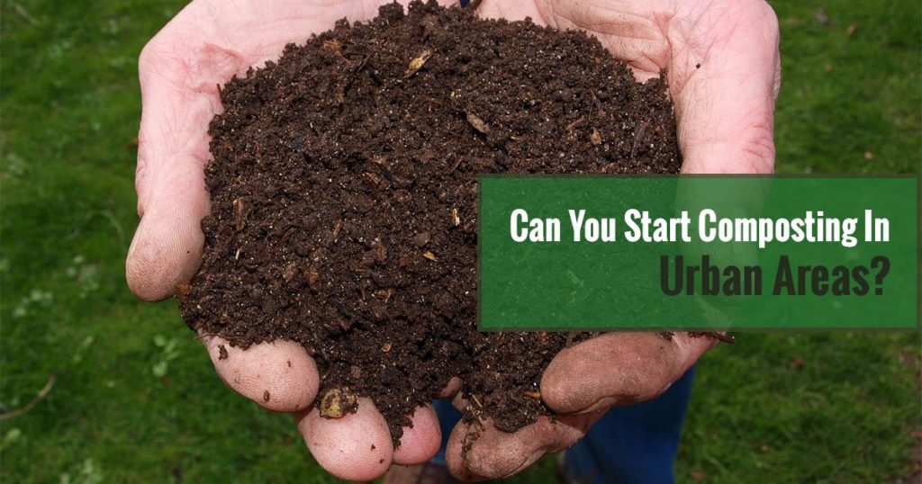 Rich dark compost material held in two hands with the text: Can You Start Composting In Urban Areas?