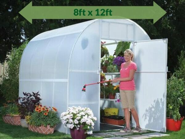Solexx 8ft x 12ft Gardener's Oasis Greenhouse G-212 - open door - a woman watering the flowers outside - green arrow on top showing dimensions