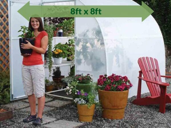 Solexx  8ft x 8ft Harvester Greenhouse G-408 - full view - green arrow on top  showing dimensions -  a woman outside holding a pot with plants
