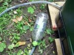 Aerobin 400 Insulated Composter with a pipe attached to a bottle