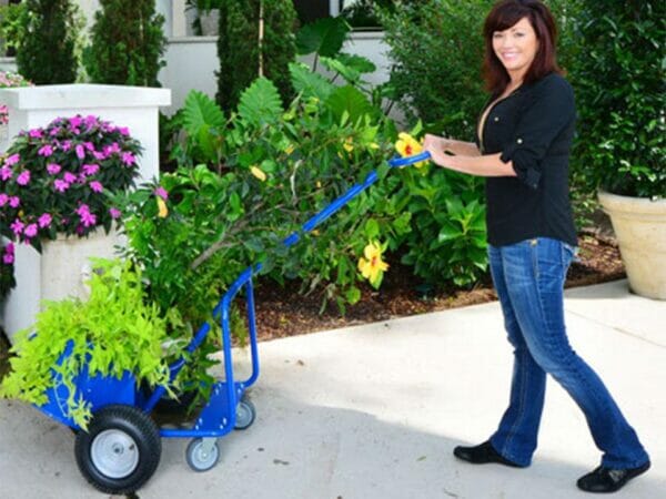 A woman on the right side pulling the blue Potwheelz carrying plants