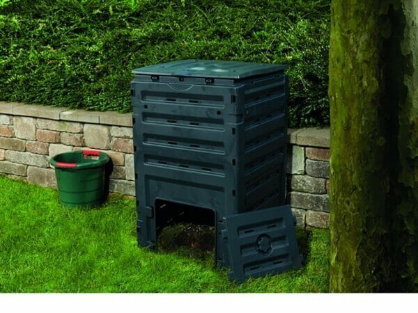 Eco Master 450 Compost Bin with an open bottom. There is also a green pail beside the bin on the left side.