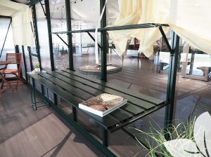 Green Exaco Slatted Greenhouse Shelving installed in a Janssens Greenhouse