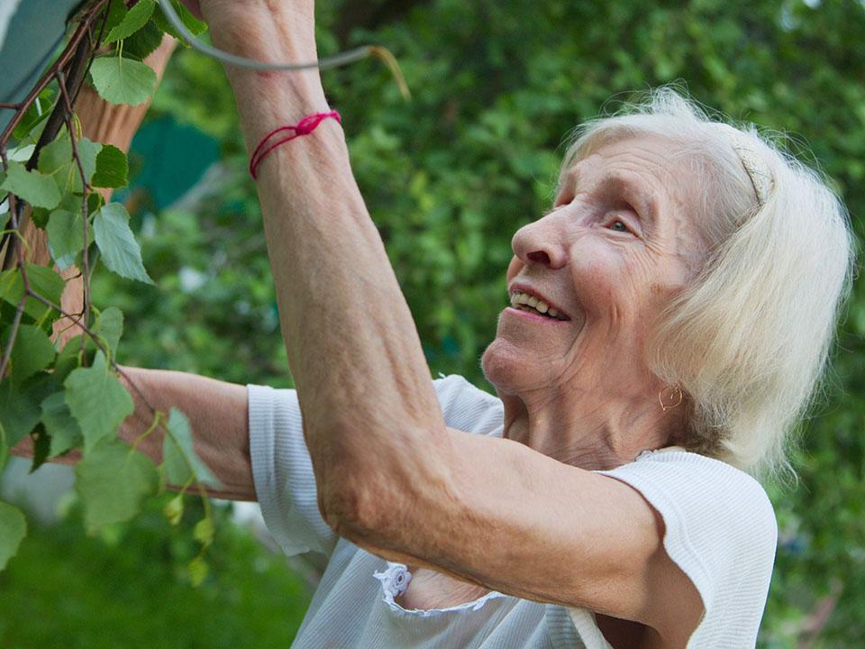 Old woman with a smile in her garden