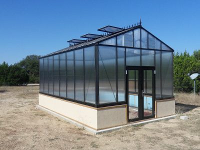 Janssens Royal Victorian Greenhouse installed on a stem wall with a door drop kit