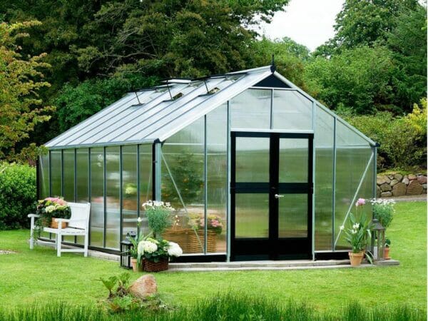 Juliana Gardener Greenhouse 12ft x 19ft - 10mm Polycarbonate - front and side view - in a garden