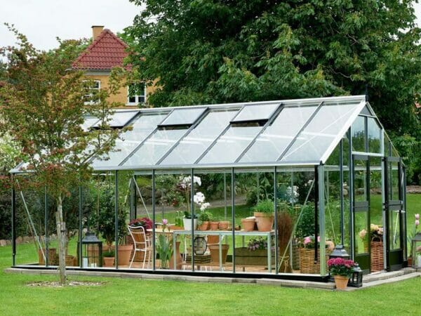 Juliana Gardener Greenhouse 12ft x 19ft - 3mm toughened glass - front and side view - in a garden