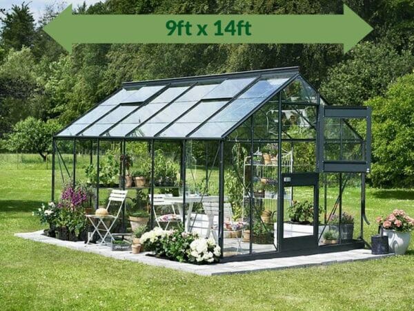 Juliana Junior Greenhouse 9ft X 14ft - 3mm glass - in a garden - green arrow on top showing dimensions