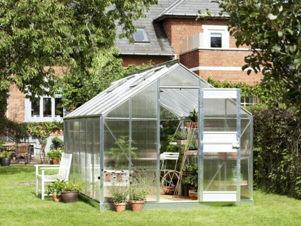 Juliana Junior Greenhouse 9ft x 14ft - Aluminum 6 mm Polycarbonate - double hinged door open - in a garden