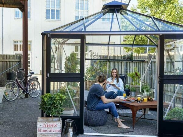 Juliana Oasis Greenhouse 10ft x 10ft Aluminum with two people having meals inside