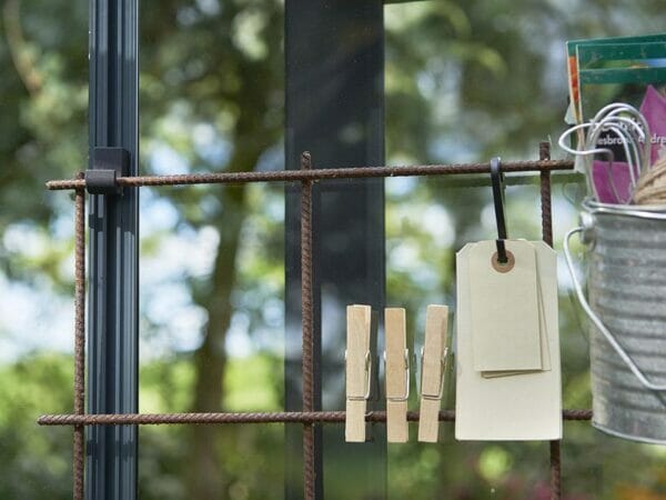 Metal frame for gardening tools hanging on the Juliana Greenhouse Frame Hooks