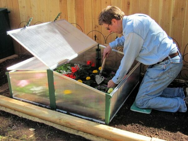 Man planting flowers in the Juwel Easy-Fix Double Cold Frame