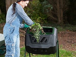 Woman puts organic waste into the Mr. Spin Dual Compartment Compost Tumbler