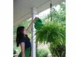 Plant Caddie Hook with a woman on the left side watering her plants