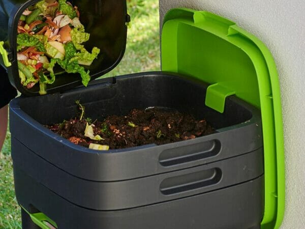 MAZE Worm Farm with open lid at the top and person pouring kitchen scraps into tray