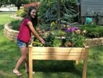 Riverstone Eden Mini Greenhouse - Growing bed - a girl standing by the growing bed