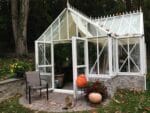 Frontal side view of the Janssens T-Shaped Royal Victorian Antique Orangerie with open double swinging door on stone stem wall