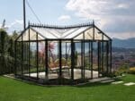 Janssens T-Shaped Royal Victorian Orangerie 10ft x 16ft in a garden with great view of mountains and a lake