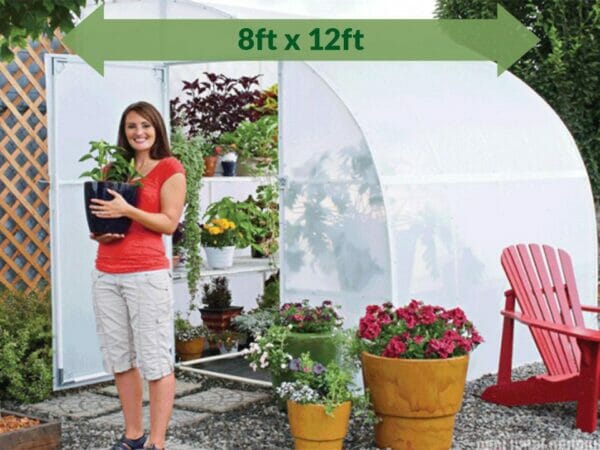 Solexx  8ft x 12ft Harvester Greenhouse G-412 - full view - open doors - green arrow on top showing dimensions - a woman carrying a pot