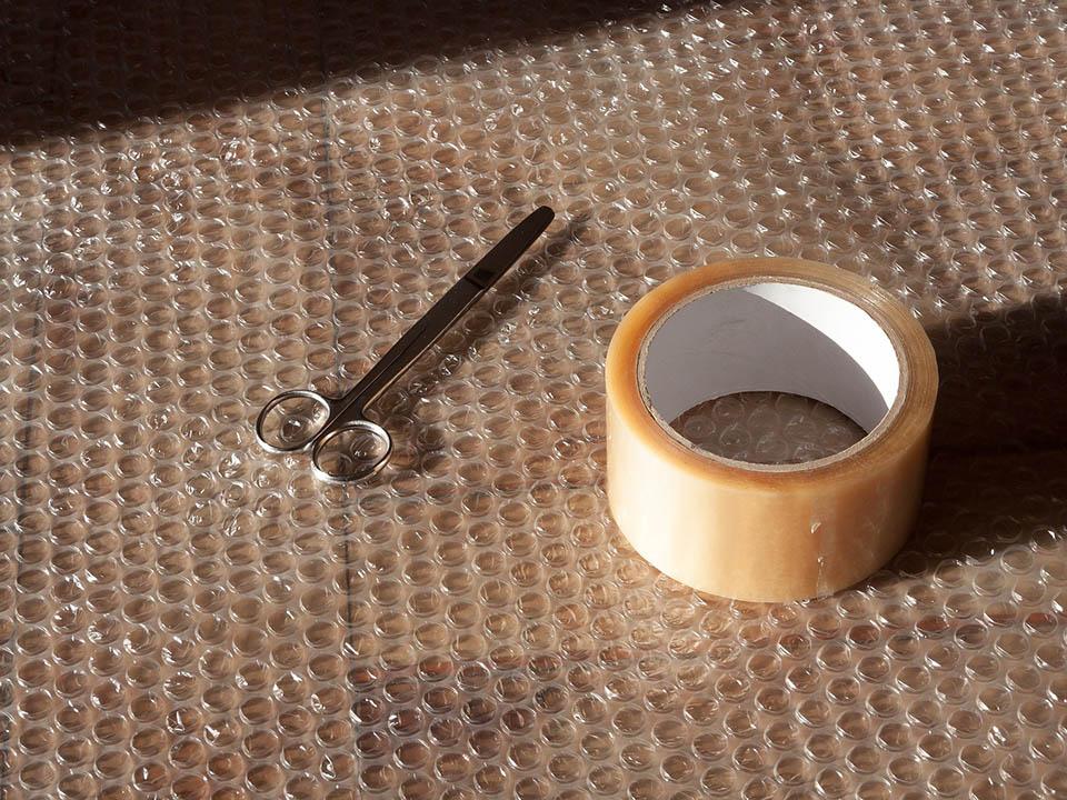 A bubble wrap with a scissor and scotch tape