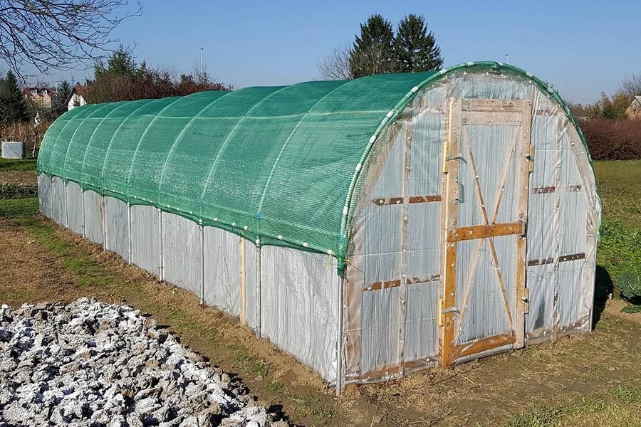 Windsor Combi greenhouse is a wooden greenhouse that is like a hoop house