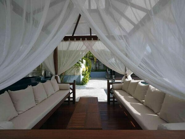 Interior view of Handcrafted Balinese Solid Wood Gazebo with bench, cushions, pillows and tied mosquito nettings