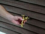 Man setting up the faucet of Slatted Rain Barrel