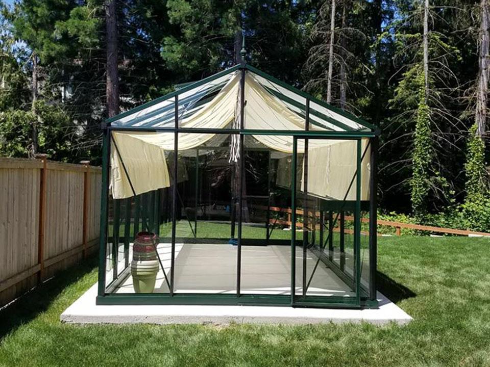 Glass greenhouse on a concrete slab as a greenhouse foundation