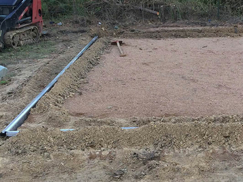 Greenhouse base frame buried in compacted soil as a greenhouse foundation