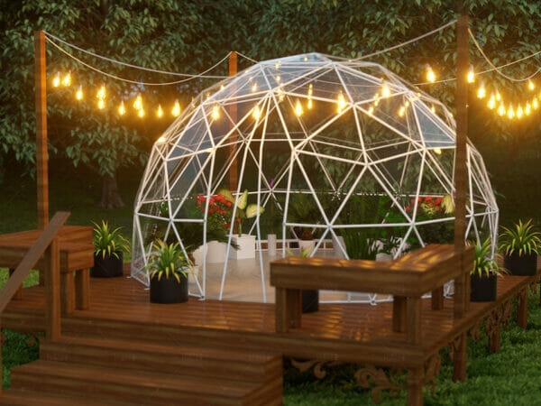 Lumen & Forge 13ft Geodesic Dome greenhouse with white steel frame and clear vinyl cover, night scene, on deck with string lights for illumination