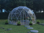 Lumen & Forge 16ft Geodesic dome, clear vinyl cover, on grass lawn with stone stepping stones leading to open zippered door