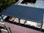 Aerial view of rooftop Selt System Sunbreaker 400 Pergola installation, black, slats closed