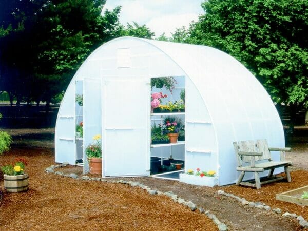 Conservatory greenhouse, arched greenhouse with two open doors, interior shelves with plants