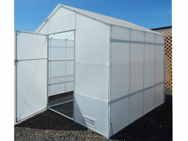 Exterior of A-frame greenhouse, door open, empty wire shelving visible in interior