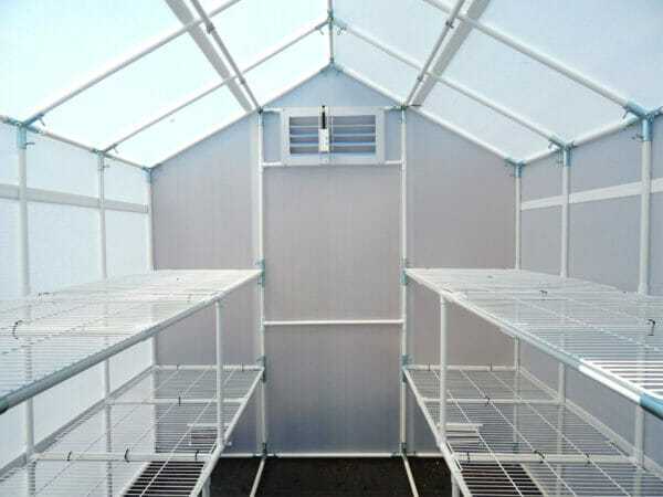 Interior view A-frame greenhouse, facing rear wall, empty wire shelving on both side walls running length of wall