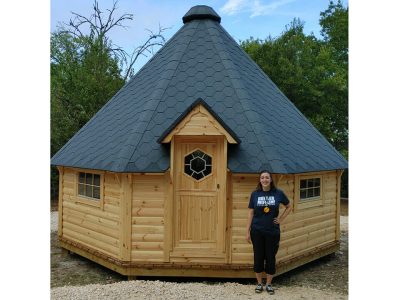 Wooden Pyramid Cabin with woman standing in front