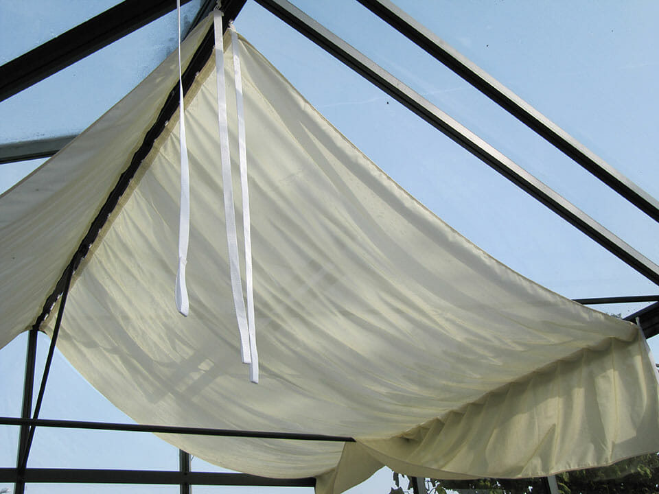 Cream colored shade curtains inside a Janssens greenhouse