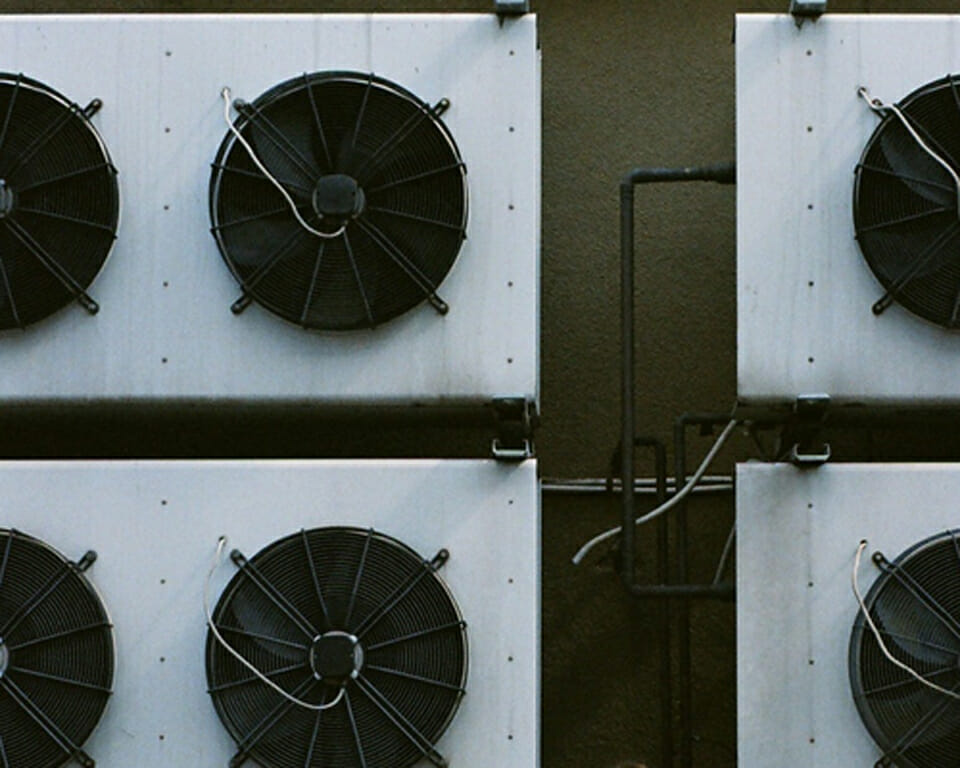 Exterior view of greenhouse fans that reduce humidity in a greenhouse