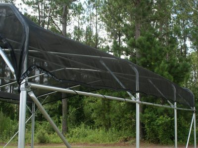 Black woven shade cloth with metal grommets over metal frame