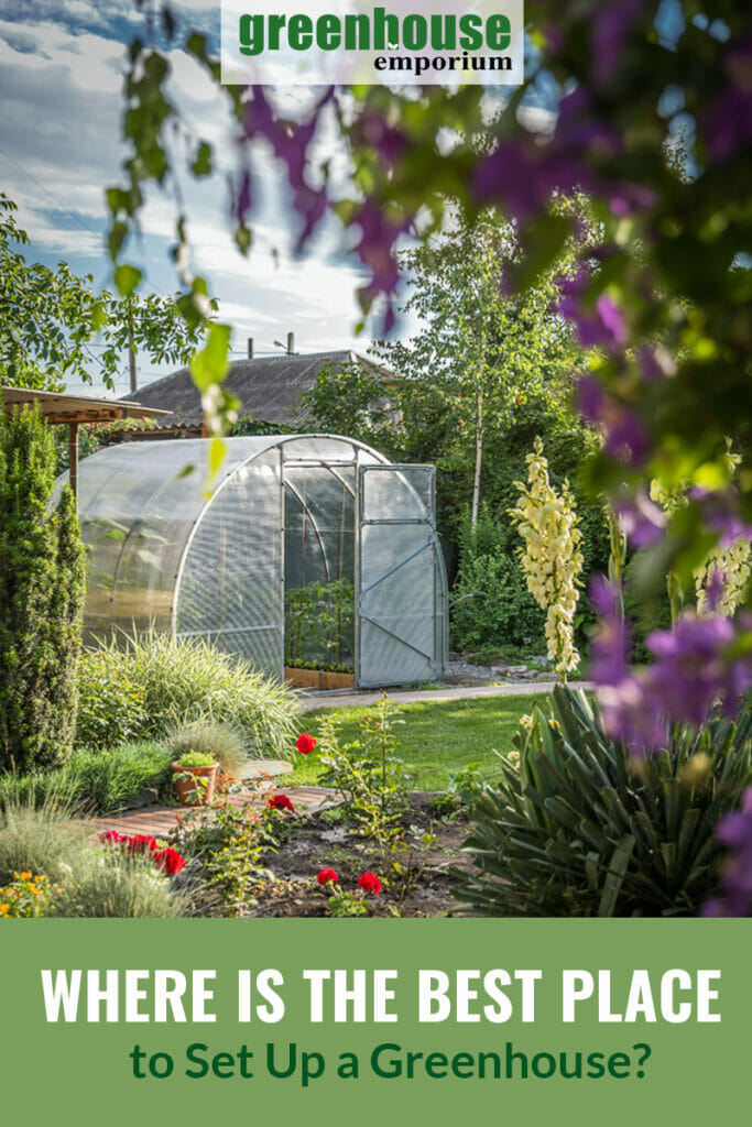 Image with purple flowers and garden in foreground, arched roof greenhouse in background, with text: Where is the Best Place to Set Up a Greenhouse?