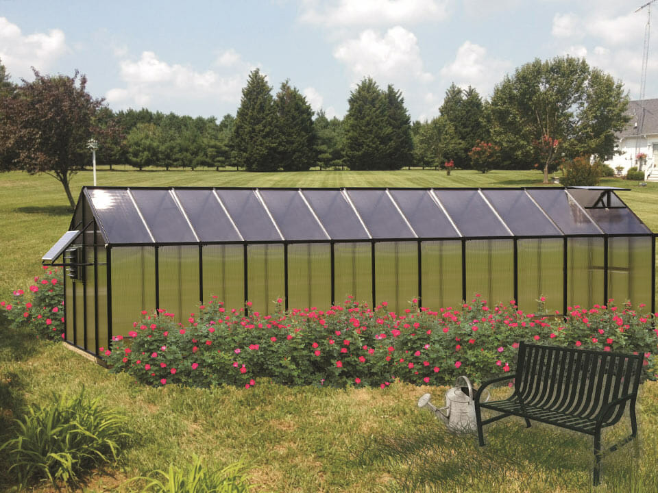 MONT 8x24 Greenhouse - Moheat Edition with a solar fan and tinted roof panels in a garden setting