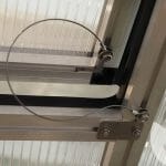 Wire on Riga roof window wind restraint system