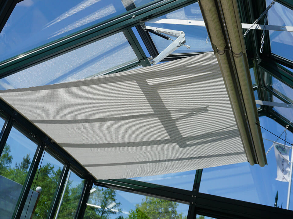 Top-mounted Retractable Roll-up Shade Curtains installed and unfurled in a greenhouse