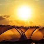 Sun over hoop greenhouses with text: Off-Grid Food Production A Reality or a Myth?
