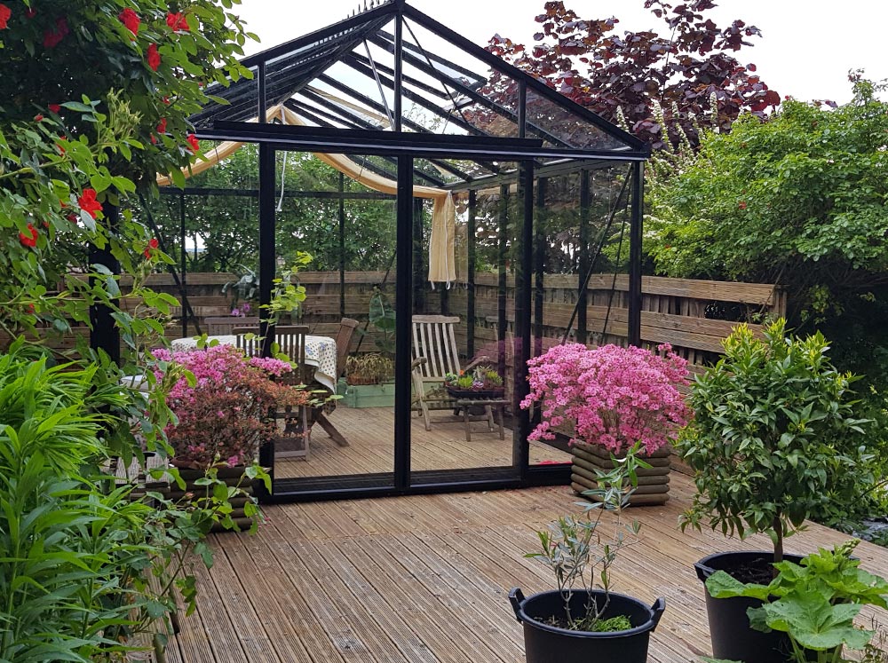 Exaco Janssens Royal Victorian VI34 Greenhouse on a wooden patio