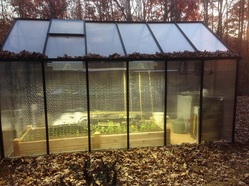 Side view of Riverstone MONT Greenhouse with lights on inside