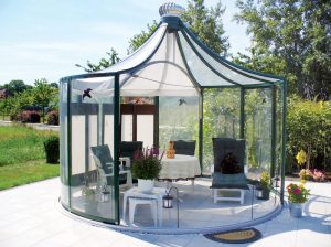 Rondo Glass Pavilion with rotating walls in a backyard setting