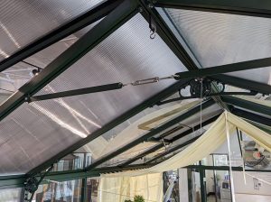 Greenhouse with support brace across the beams