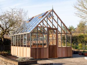 Alton Westminster Wooden Greenhouse in a backyard