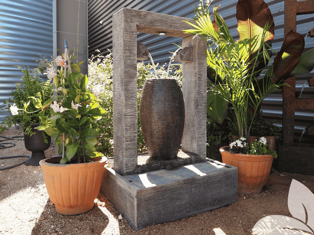 Black rectangle Trevi Fountain with hollow center with two spouts coming out of the interior of each side pouring over an oblong shape with the top cut off. 53" tall with a 31" square base made of GRC, includes 1 LED light, a weight of 608 lbs, and a 396 GPH Pump.